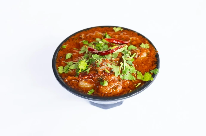 a black bowl filled with food on top of a white table
